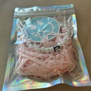 White evil eye bracelet with blue smiley sticker